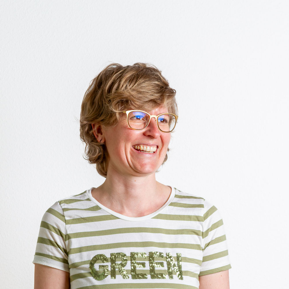 Antonia Meichelböck herzlich lachend im grünen T-Shirt.